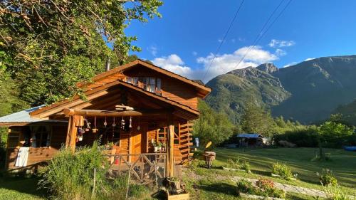 a log cabin with mountains in the background at Cabañas Sol de Montañas in Futaleufú