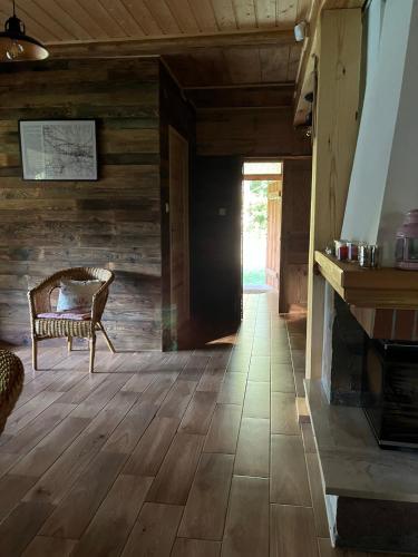 a living room with a chair and a fireplace at Dom w krainie Bugu in Korczew