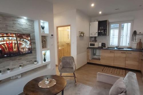 un salon avec un canapé et une table et une cuisine dans l'établissement l' immeuble Booking à Chalon sur Saône, à Chalon-sur-Saône