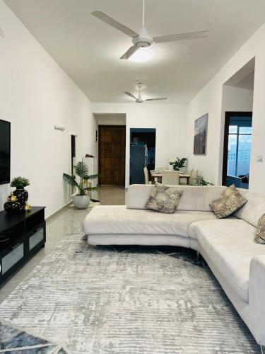a living room with a white couch and a tv at Nemra IVY in Colombo