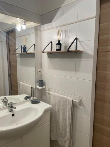une salle de bain blanche avec un lavabo et un miroir dans l'établissement Appartement 2 pièces bord de mer, à Linguizzetta