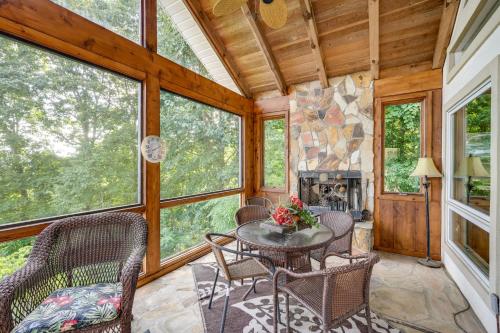 a living room with a table and chairs and a fireplace at Stunning Hiawassee Hideaway with Impeccable Views! in Hiawassee
