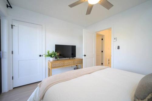 a white bedroom with a bed and a television at Mountainside Ski & Golf Retreat in Eden