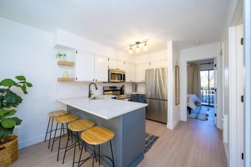 a kitchen with white cabinets and a island with bar stools at Mountainside Ski & Golf Retreat in Eden
