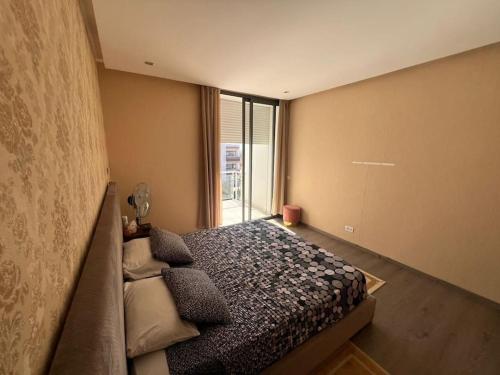 a bedroom with a bed and a large window at 150 M2 Appartement Residence Picine Tamaris in Casablanca