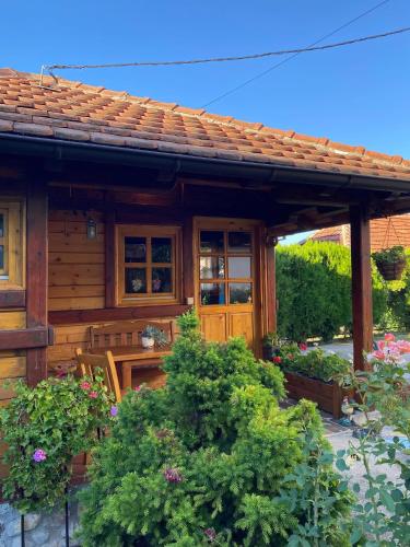 a log cabin with a porch and some plants at Flowers Cabin in Valjevo