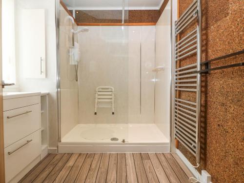 a bathroom with a shower with a chair in it at The Headland in Amlwch