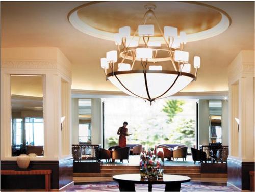 a man standing in a lobby with a large chandelier at Shangri-La Harbin in Harbin