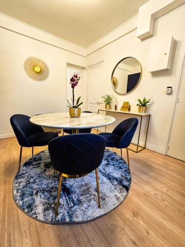 une salle à manger avec une table et des chaises sur un tapis dans l'établissement Appartement 2 étoiles cosy et chic à Vaires sur Marne Entre disney et Paris, à Vaires-sur-Marne