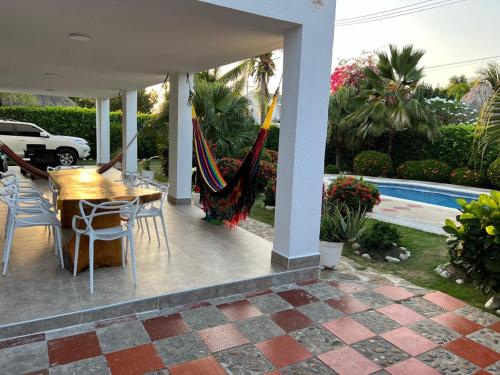 a patio with a table and chairs and a hammock at Villa Las Marias in Santa Veronica