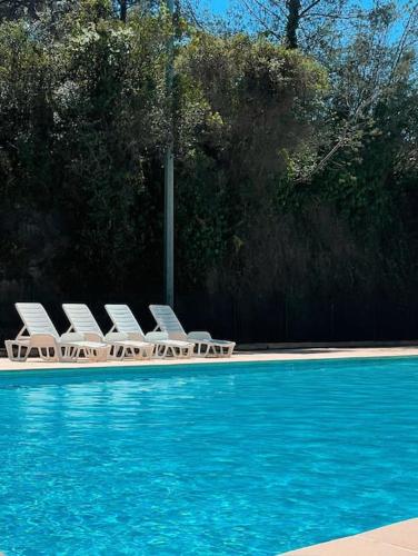 un groupe de chaises assises à côté d'une piscine dans l'établissement T2 4 personnes proche des plages, à Saint-Raphaël