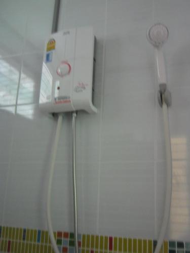 a shower in a bathroom with a hair dryer on the wall at Dr. House in Campson