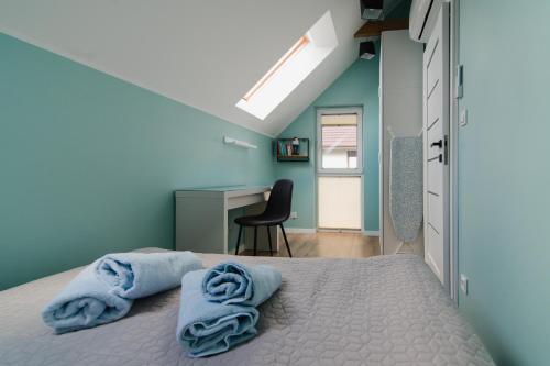 a bedroom with blue walls and a bed with towels on it at AROMA DĘBKI Całoroczny prywatny dom na zamkniętym osiedlu. in Dębki