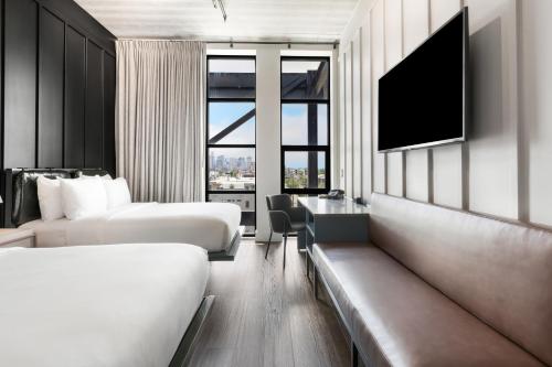 a hotel room with two beds and a television at Waymore's Guest House & Casual Club in Nashville
