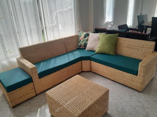 a wicker couch with a bench and a table at Villa Las Marias in Santa Veronica