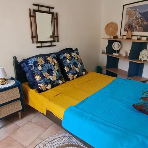 - une chambre dotée d'un lit avec des draps bleus et jaunes dans l'établissement Maison Casa Maria, à Corbara