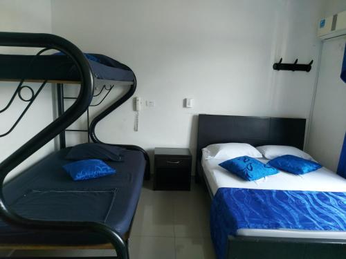 a bedroom with two beds with blue pillows at Hotel Perla Azul Boutique in Girardot