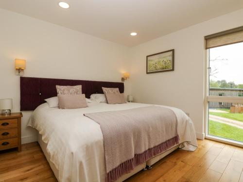 Un dormitorio con una cama grande y una ventana. en Ash, en Truro