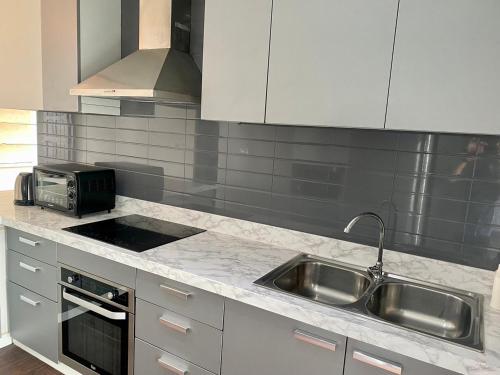 a kitchen with a sink and a microwave at W8 CONDO, TOP Floor LUXE 3 Bedroom Penthouse, Hip central Bangkok area, 5 mins from Thonglo BTS station in Bangkok