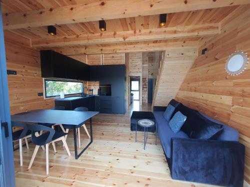 a living room with a blue couch and a table at modernes Holzhaus, Cabin, auf dem Fluss, wenige Meter zum Meer in Ulcinj