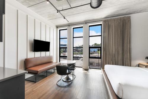 a hotel room with a bed and a couch and a television at Waymore's Guest House & Casual Club in Nashville