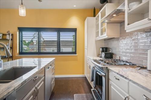 a kitchen with a sink and a stove top oven at VioletSuitesPDX Boutique Hotel in Portland