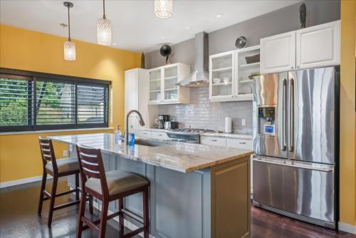 a kitchen with white cabinets and a stainless steel refrigerator at VioletSuitesPDX Boutique Hotel in Portland