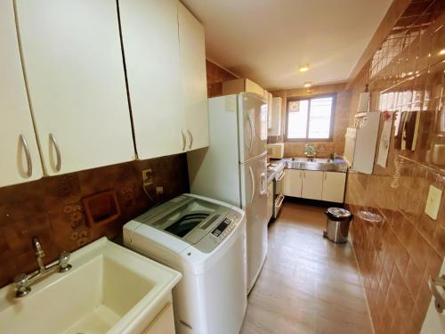 a small kitchen with a white refrigerator and a sink at Pampa Downtown Lodge in Mendoza