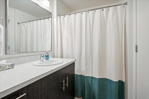 a bathroom with a sink and a shower curtain at VioletSuitesPDX Boutique Hotel in Portland