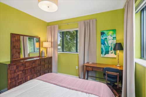 a bedroom with a bed and a desk and window at VioletSuitesPDX Boutique Hotel in Portland