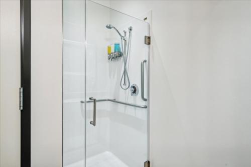 a shower with a glass door in a bathroom at VioletSuitesPDX Boutique Hotel in Portland