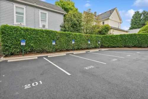 a parking lot with parking meters in front of a hedge at VioletSuitesPDX Boutique Hotel in Portland