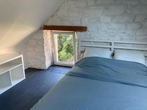 une chambre avec un lit et une fenêtre dans l'établissement Belle maison en Bretagne - Saint Jacques, à Sibiril