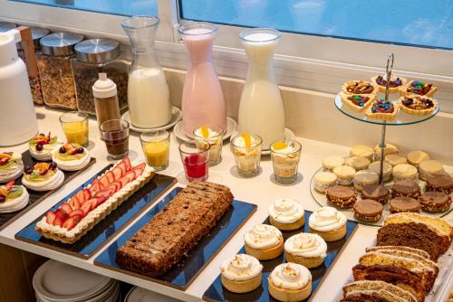 a buffet filled with different types of cakes and pastries at Hotel Traful in Mar del Plata