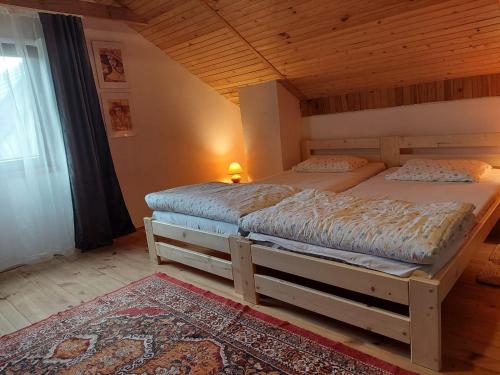 two twin beds in a room with a wooden ceiling at Domek nad jeziorem, łódka, kajak in Zalewo