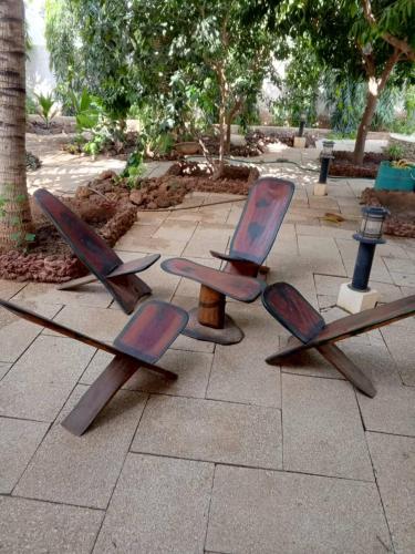 a group of wooden chairs sitting on a sidewalk at Villa chez ibou somone in Somone