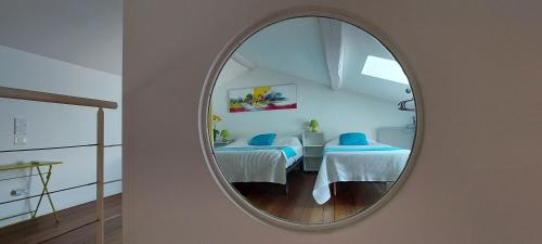 - un miroir mural avec 2 lits dans une chambre dans l'établissement Le Loft De La Robine 110m2, à Narbonne