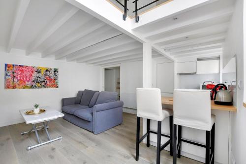 un salon avec un canapé bleu, une table et des chaises dans l'établissement Duplex Notre-Dame de Paris, à Paris