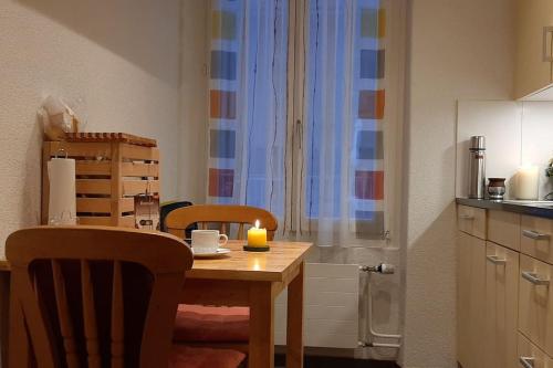 a kitchen with a wooden table with a candle on it at Bern room near Main Station in Bern