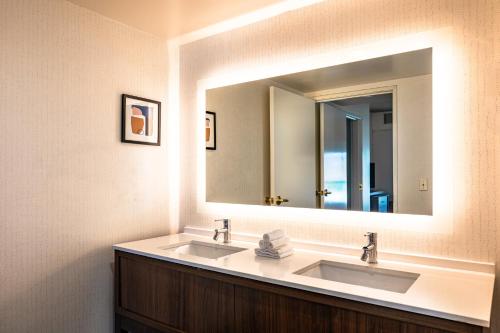 オークランドにあるHoliday Inn Oakland Airport by IHGのバスルーム(シンク2台、大きな鏡付)