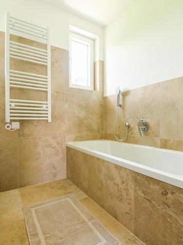 a bathroom with a tub and a window at Entspannung und Erholung, Ferienwohnung mit traumhaftem Blick in die Natur in Oberaurach
