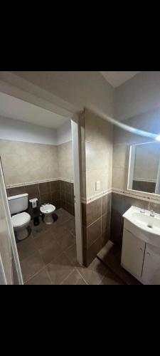 Un baño con dos inodoros y un lavabo. en departamentos CV, en Villa Mercedes