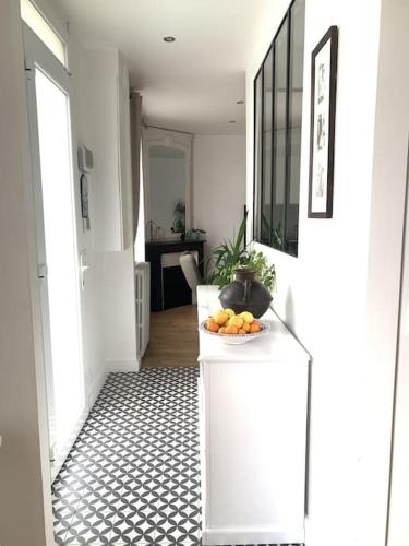 ein Flur mit einer Schale Orangen auf einem Tisch in der Unterkunft Douceur de vivre in Neuilly-Plaisance