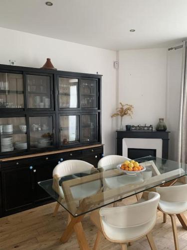 ein Esszimmer mit Glastisch und Stühlen in der Unterkunft Douceur de vivre in Neuilly-Plaisance
