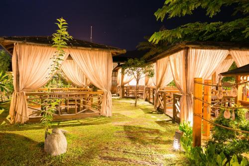 a restaurant with tables and curtains in a yard at Grand Orchid Resort Villa in Liugui