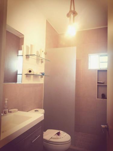 a bathroom with a white toilet and a sink at Ela in Playa del Carmen