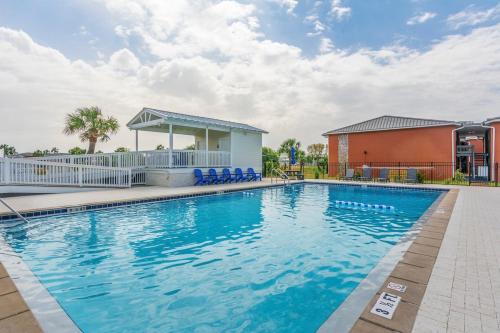デスティンにあるSandy Beaches-3 Pools-Pet Friendlyの建物の隣に青い椅子付きのスイミングプール