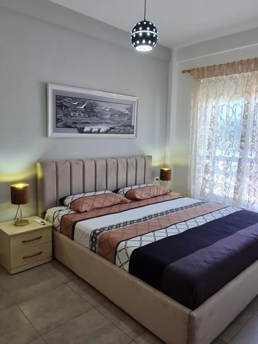 a bedroom with a large bed in a room at Gjiri I Lalzit apartament in Durrës