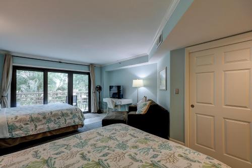 a bedroom with two beds and a door with a desk at Wonderful Luxury Updated Villamare with Pool Bikes & Beach Gear included in Hilton Head Island
