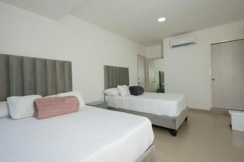 a hotel room with two beds and a television at Hotel orange sanfernando in Cali